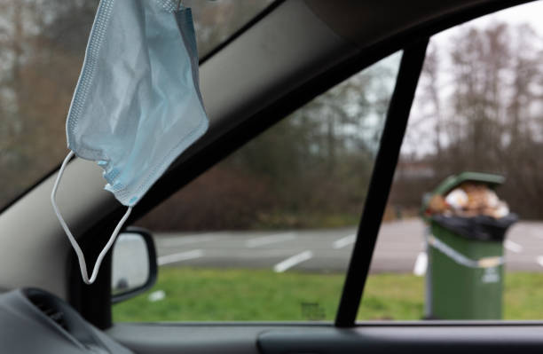 istock face mask inside the car. hanging on the rearview mirror 1357090670