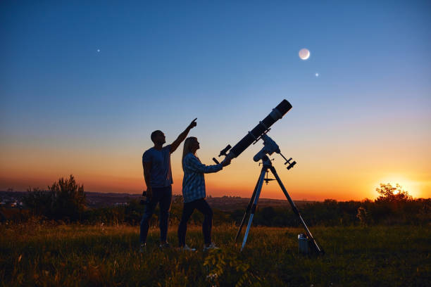 istock Couple stargazing together with a astronomical telescope. 1357090791