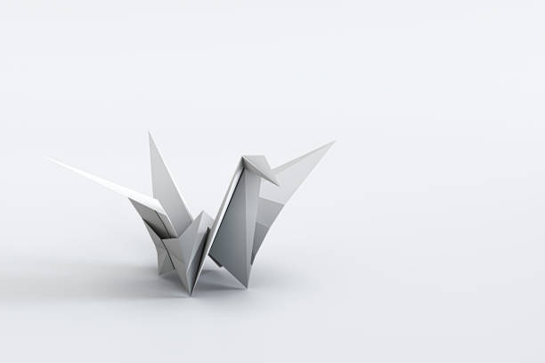 Blank origami penguin parent and child on a wooden shelf against blue wall.