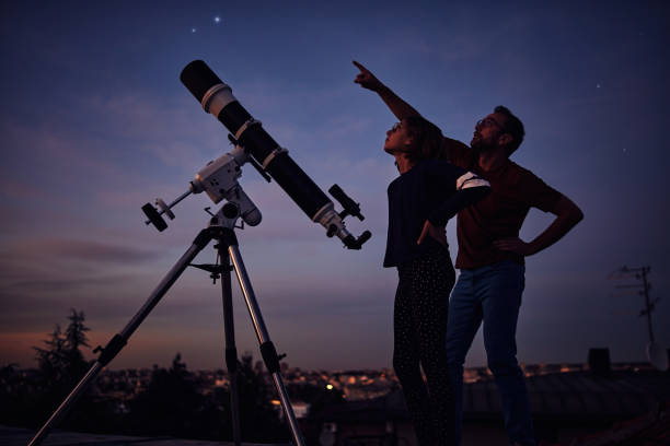 silhouettes de père, fille et télescope astronomique sous un ciel étoilé. - astronomie photos et images de collection