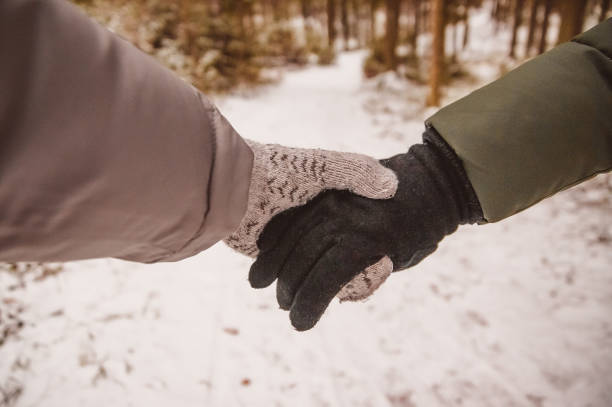 istock The couple holds hands in mittens. 1357091808