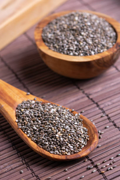 chia seeds on a wooden spoon on the table close-up Healthy Chia seeds in a wooden spoon on the table close-up. eating chia seeds stock pictures, royalty-free photos & images