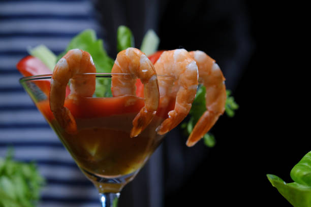 Shrimp cocktail Person is serving shrimp cocktail in martini glass shrimp cocktail stock pictures, royalty-free photos & images