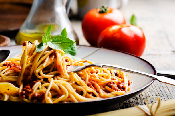 italienische spaghetti auf rustikalem holztisch - italienische küche stock-fotos und bilder