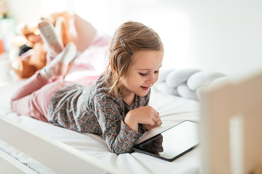 Girl with tablet in bedroom