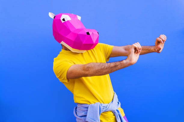 Cool man wearing 3d origami mask with stylish colored clothes - Creative concept for advertising, animal head mask doing funny things on colorful background