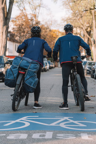 istock Couple ride e-mountain bikes through city 1357100525