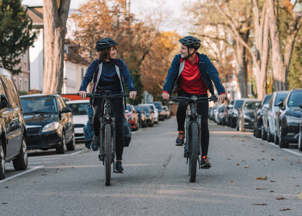 istock Couple ride e-mountain bikes through city 1357100526