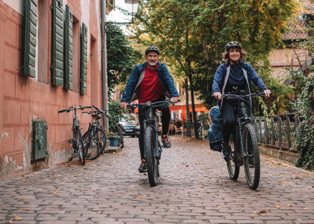 istock Couple ride e-mountain bikes through city 1357100582