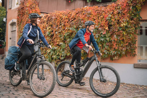 Couple ride e-mountain bikes through city