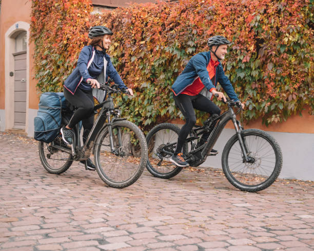 istock Couple ride e-mountain bikes through city 1357100585