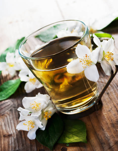 taza de té de jazmín sobre mesa de madera - tea tea leaves jasmine tea leaf fotografías e imágenes de stock
