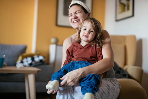 istock Mother dressing up two year old daughter in messy room 1357101634