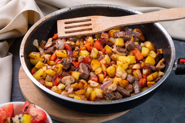 istock Fried potatoes with mushrooms and meat in a pan. 1357101779