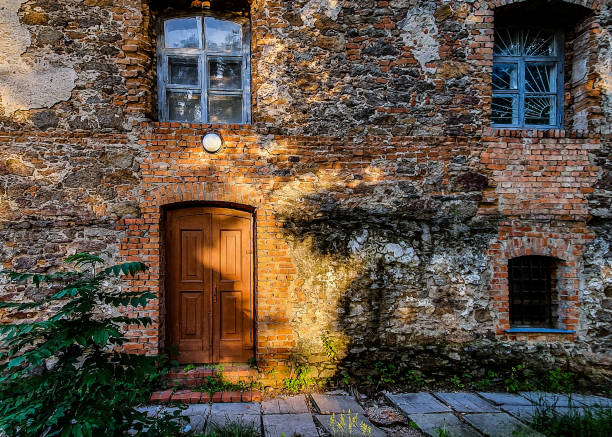 residential building of the last century. background of shabby and dirty brickwork with old wooden windows and doors - antique old fashioned close up color image imagens e fotografias de stock