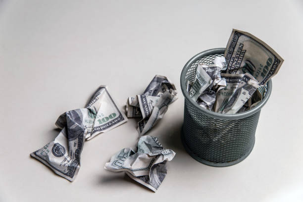 istock Several crumpled $100 bills were thrown in a small bin. 1357105839