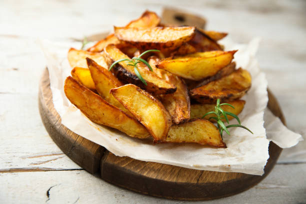 cuñas de patata asada - patata al horno fotografías e imágenes de stock