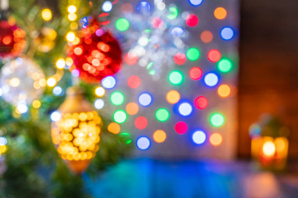 Blurred Christmas fir tree background with baubles, snowflake and glowing Christmas lights bokeh