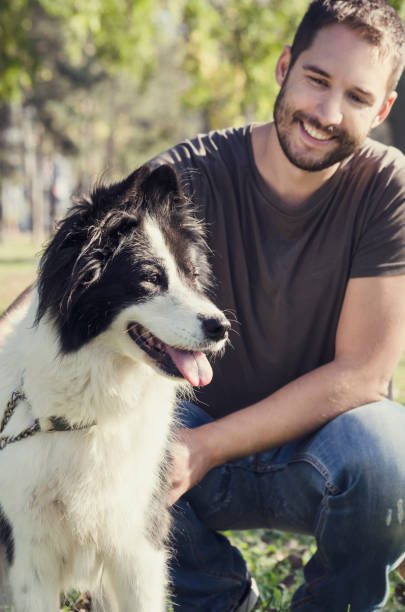 istock Man and his dog playing in the park 1357109981