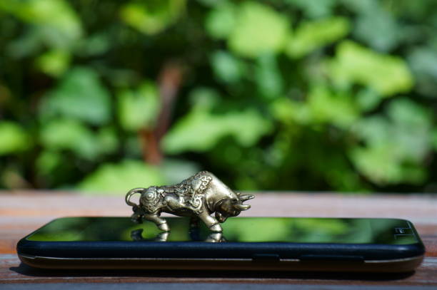 istock Metal bull on a mobile phone close-up. 1357110558