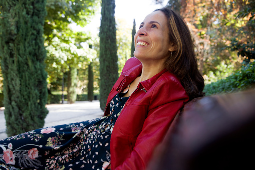 happy woman sitting on a park bench