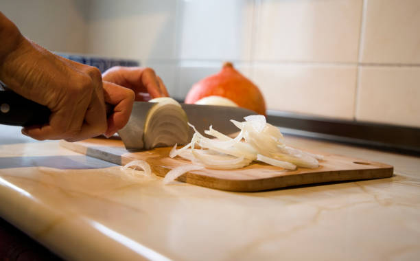 sharp knife cutting onion on top of the board