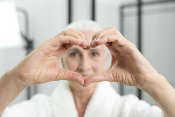 istock Pretty senior lady making love symbol with hands 1357113859