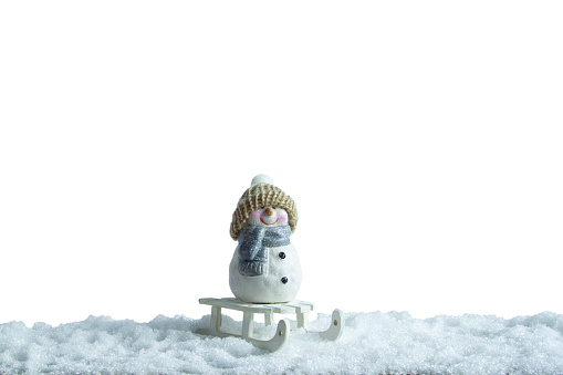 Christmas toy in the snow on a white background. A snowman in the snow on a white background.