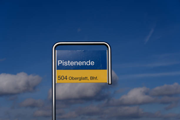 close-up de sinal azul e amarelo na rodoviária chamada pistenende (alemão, tradução final da pista) em um dia nublado de inverno. - blue outdoors nobody switzerland - fotografias e filmes do acervo
