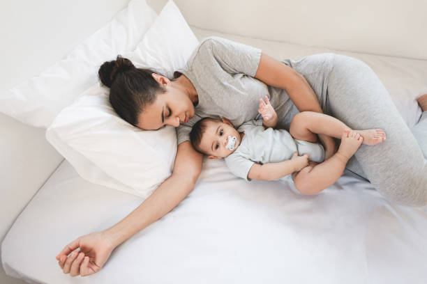 istock Young mother lying with her son on bed at home - Focus on faces 1357123856