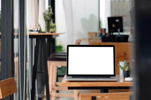 istock Mockup blank white screen laptop computer on wooden table. 1357125743