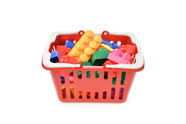 Plastic toy blocks in a basket isolated on white background