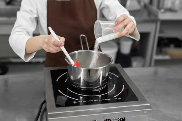 istock Pastry chef pours the sugar into a saucepan. 1357128009
