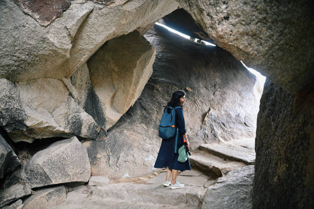 istock Woman walking inside stone caves 1357128056