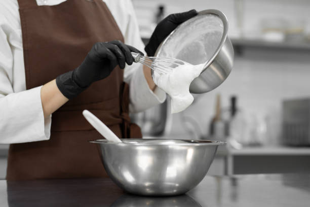 istock Pastry chef adds whipped cream to a white chocolate mousse. 1357128253