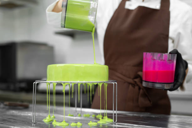 istock Close up woman decorating cake with glaze 1357128369
