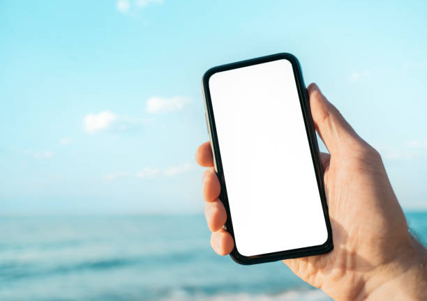 Man holds a cell phone with a blank screen for mock up. stock photo