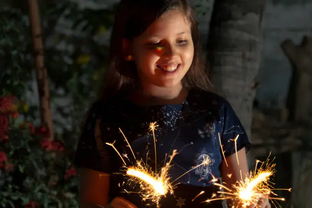 Photo of Young latin little girl outside celebrating New year's or Christmas Holidays playing with sparkles fireworks at Ecuador, Latin America.

Ecuador Popular Traditions at new year's eve.