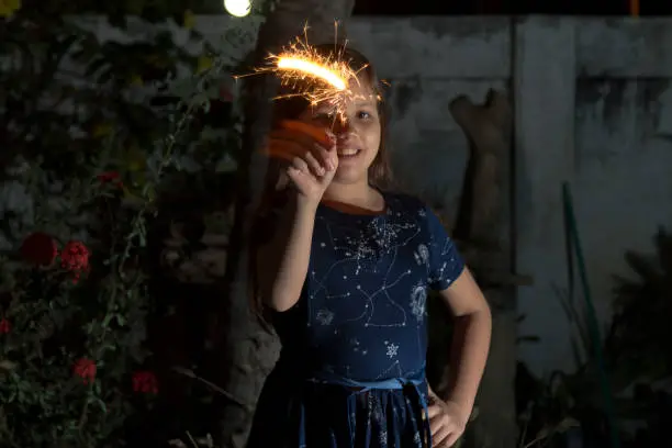 Photo of Young latin little girl outside celebrating New year's or Christmas Holidays playing with sparkles fireworks at Ecuador, Latin America.

Ecuador Popular Traditions at new year's eve.