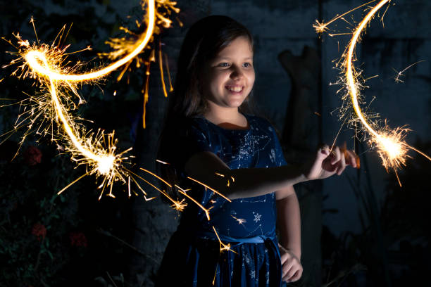 jeune fille latine à l’extérieur célébrant les vacances du nouvel an ou de noël jouant avec des feux d’artifice étincelants en équateur, en amérique latine.

traditions populaires de l’équateur à la veille du nouvel an. - new years day new years eve new year ethnic photos et images de collection