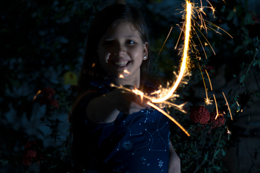 Young latin little girl outside celebrating New year's or Christmas Holidays playing with sparkles fireworks at Ecuador, Latin America.

Ecuador Popular Traditions at new year's eve.