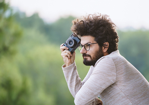 Professional photographer taking pictures with a compact digital camera, Outdoors, selective focus, Copy space