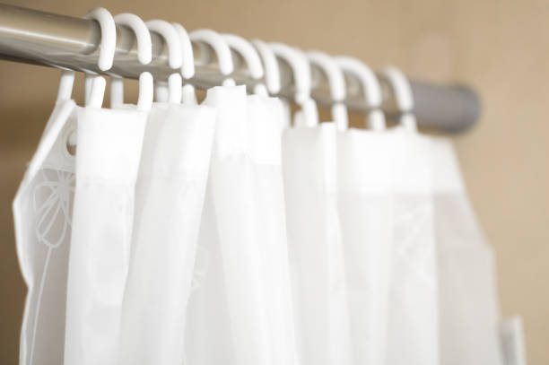 istock Blurred white plastic hooks curtains for bath. Hooks on an aluminum rod for bathroom curtains. Selective focus 1357134783