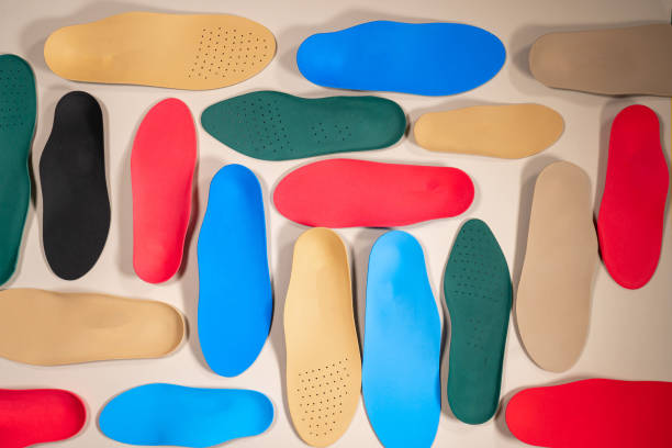orthopedic insoles are lined up on a wooden surface. samples of different orthopedic insoles. insoles with a variety of coating. - plattfot bildbanksfoton och bilder