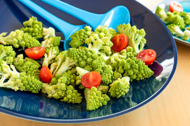 insalata di cavolfiore romanico servita in una ciotola blu - stock photo - romanesque broccoli cauliflower cabbage foto e immagini stock