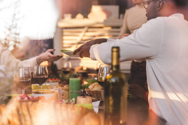 istock Friends setting up plates on a dining table before eating main dish during Christmas lunch 1357144144