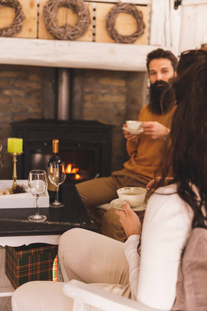istock Couple having tea in a rustic cabin, by the fireplace 1357144279