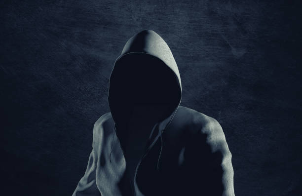 istock Man with a hood on his head with an invisible face. Hacker and cyber security concept. 1357145611