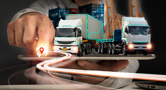 A businessman uses a tablet for logistic network distribution and smart transportation, as well as for networking intelligent logistics of container cargo ships, logistic import-export,and industrial.