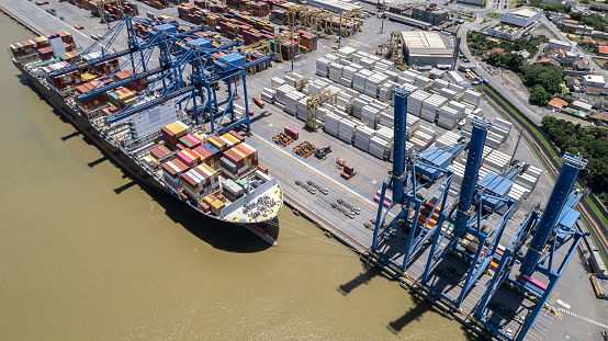 Aerial view of a large cargo ship being loaded with coal in an international port.